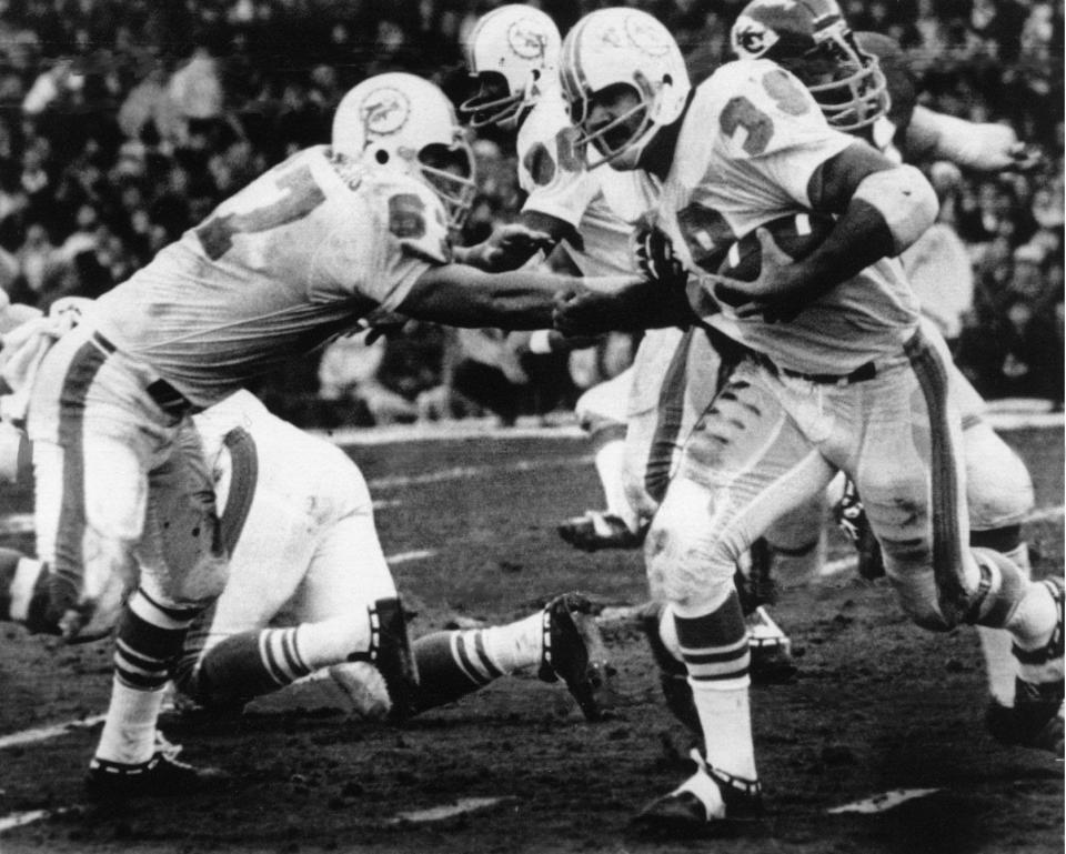 Guard Bob Kuechenberg (67) blocks for running back Larry Csonka during the Dolphins' double-overtime playoff victory against the Chiefs on Dec. 25, 1971.