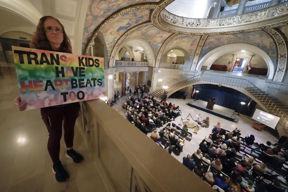 Julia Williams holds a sign in counterprotest during a rally in favor of a ban on gender-affirming health care legislation, Monday, March 20, 2023, at the Missouri Statehouse in Jefferson City, Mo. (AP Photo/Charlie Riedel)