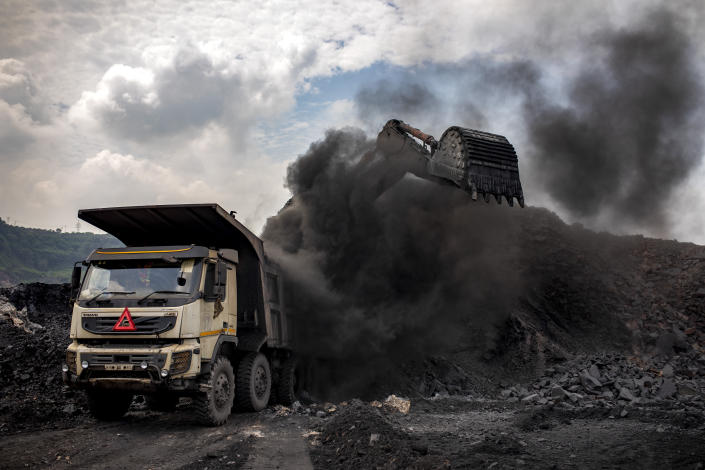Coal is loaded into a truck at an open-cast mine near Dhanbad, an eastern Indian city in Jharkhand state, Friday, Sept. 24, 2021. On Saturday, India asked for a crucial last minute-change to the final agreement at crucial climate talks in Glasgow, calling for the "phase-down" not the "phase-out" of coal power. (AP Photo/Altaf Qadri)