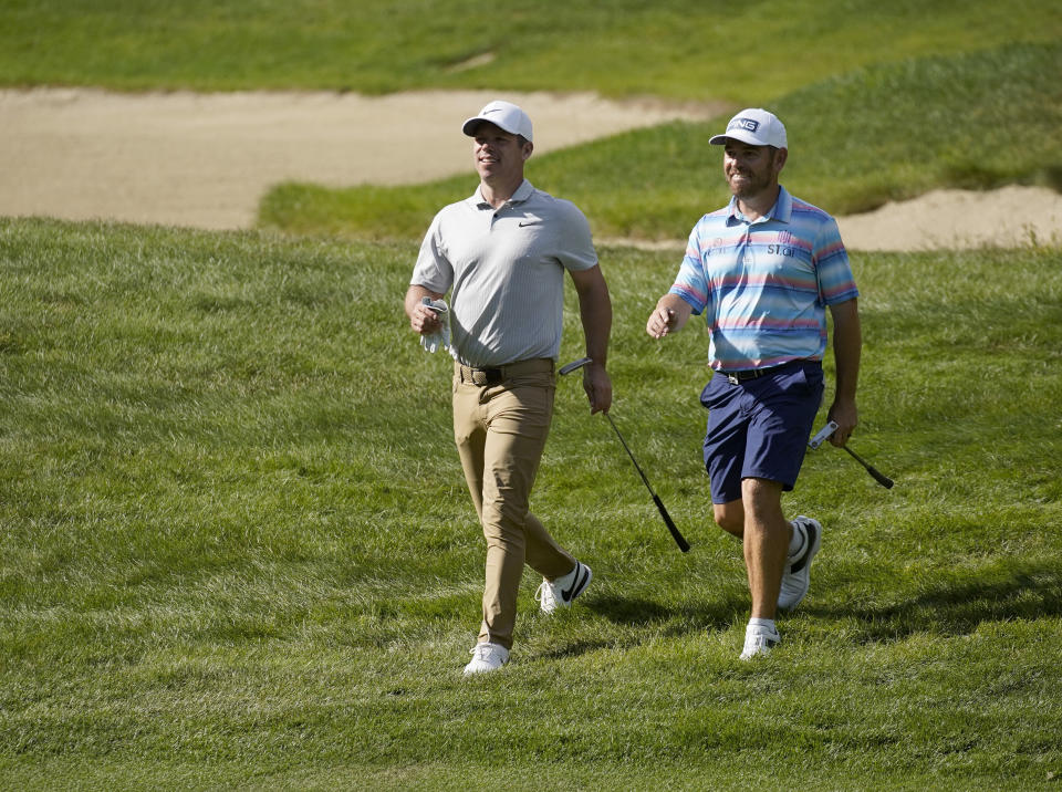 Paul Casey, left, and Louis Oosthuizen walk along the fairway to the 13th green following their tee shots during the second round of the LIV Golf Invitational-Boston tournament, Saturday, Sept. 3, 2022, in Bolton, Mass. (AP Photo/Mary Schwalm)