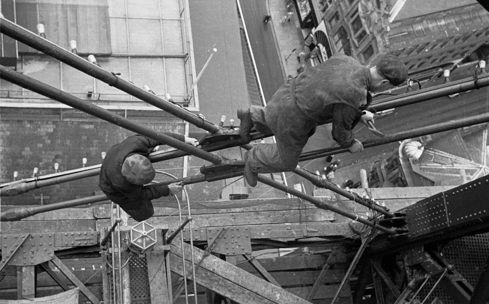 11th July 1953: Construction workers balance precariously over the streets of Blackpool over 500 feet below, as they work on the famous Tower.