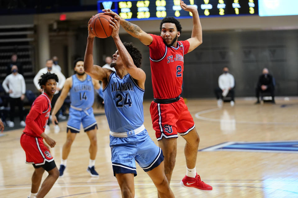 Villanova's Jeremiah Robinson-Earl (24) tries to get a shot past St. John's Julian Champagnie (2) during the first half of an NCAA college basketball game, Tuesday, Feb. 23, 2021, in Villanova, Pa. (AP Photo/Matt Slocum)