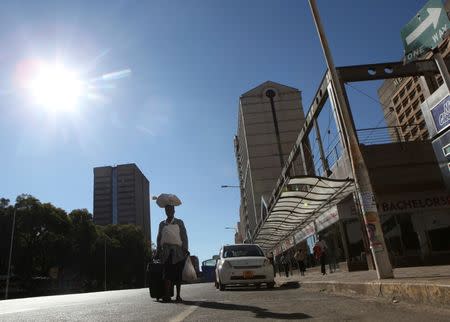 A woman walk along an empty street in the central business district of Harare, Zimbabwe, July 6, 2016. REUTERS/Philimon Bulawayo