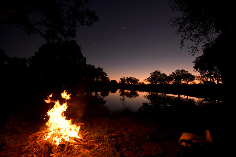 A campfire at the Darling River at sunset in the NSW outback town of Bourke