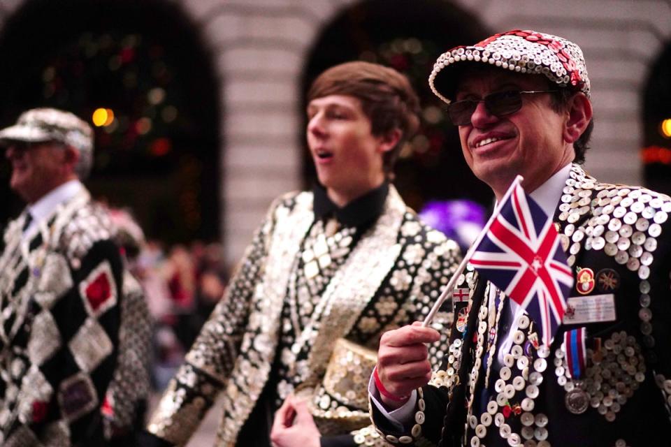 People dressed in traditional pearly king costume taking part in the parade (PA)