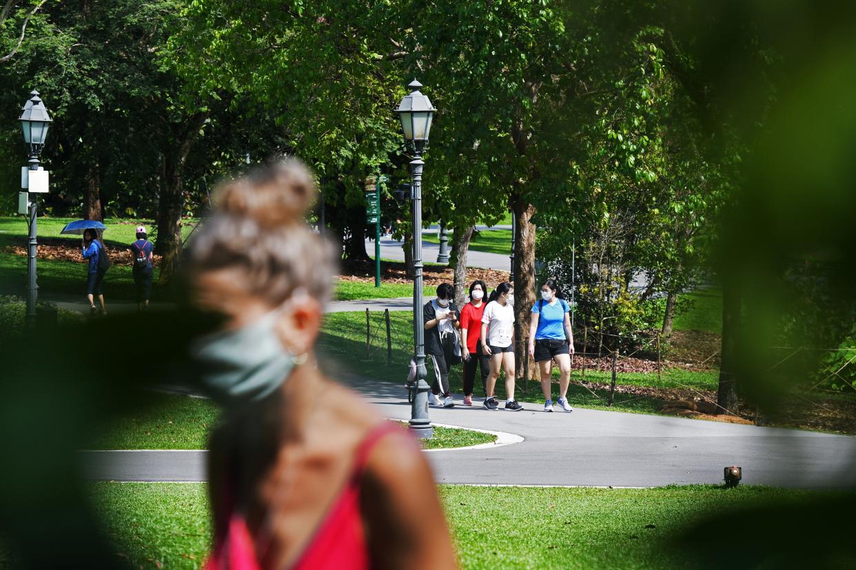 People taking walks at Singapore Botanic Gardens.