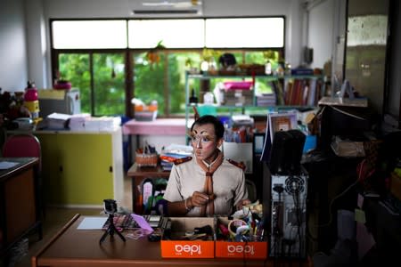 Teeraphong Meesat, 29, known as teacher Bally applies make up before his English class at the Prasartratprachakit School in Ratchaburi Province