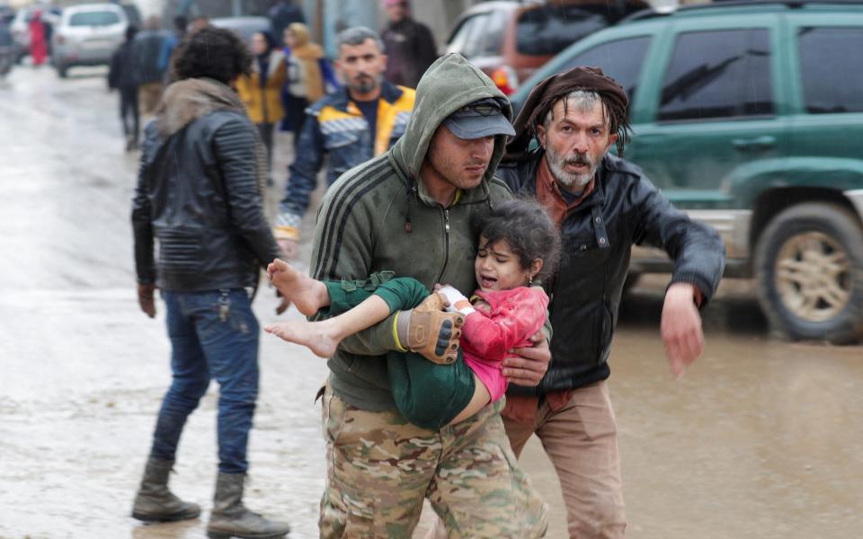 A man carries a girl in the rebel-held town of Jandaris, Syria - Reuters/Khalil Ashawi