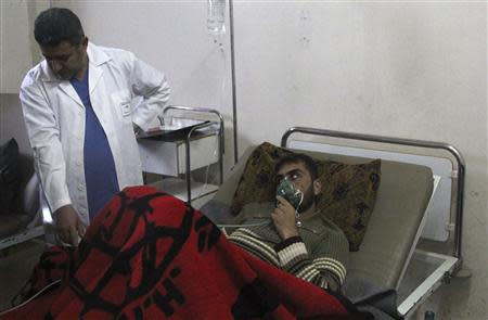 A man, affected by what activists say was a gas attack, breathes through an oxygen mask inside a field hospital in Kfar Zeita village in the central province of Hama April 12, 2014. REUTERS/Stringer