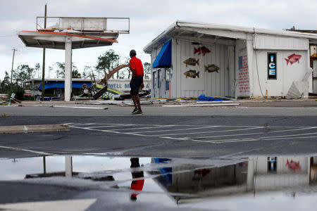 A man walks past a building damaged by Hurricane Michael in Panama City, Florida, U.S. October 11, 2018. REUTERS/Jonathan Bachman