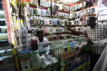 FILE PHOTO: A customer looks for a mobile phone at a market in Khartoum, Sudan July 3, 2017. REUTERS/Mohamed Nureldin Abdallah