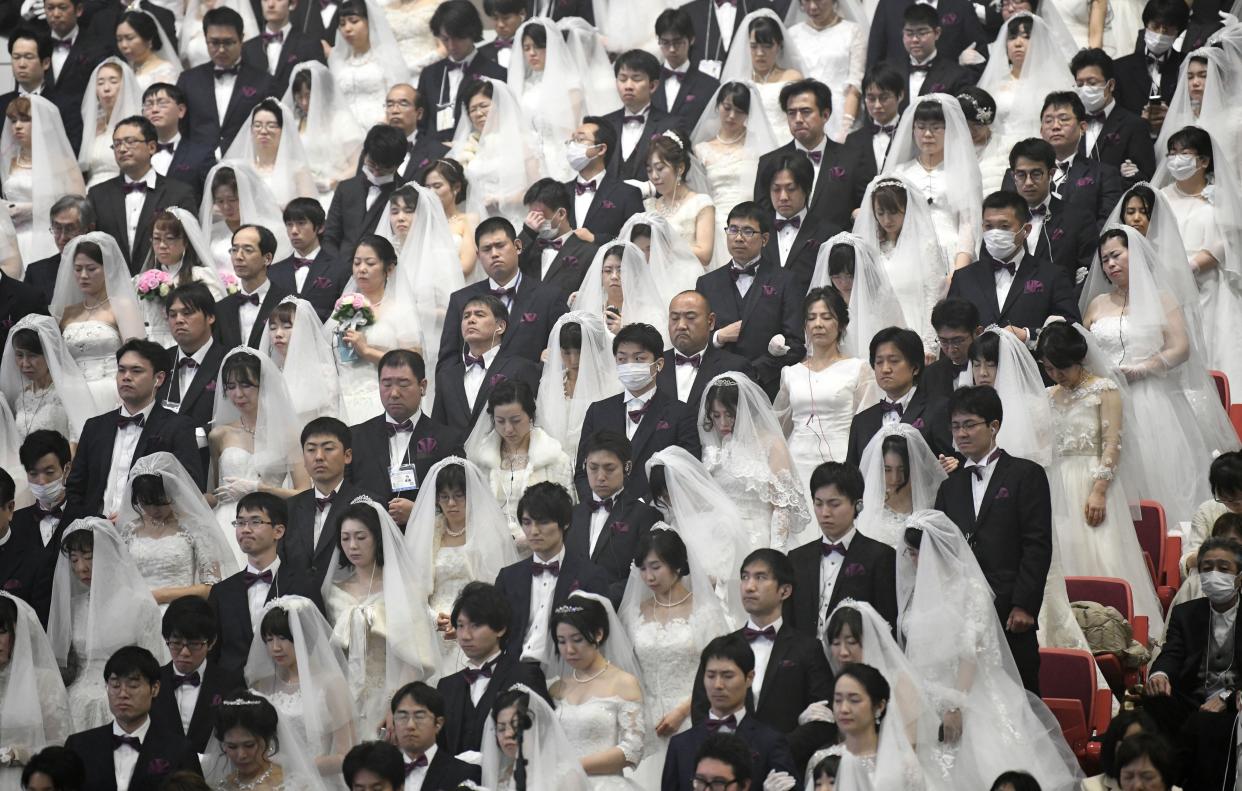 Some couples wearing protective face masks attend a mass wedding ceremony organised by the Unification Church at Cheongshim Peace World Center in Gapyeong on February 7, 2020. - South Korea has confirmed 24 cases of the SARS-like virus so far and placed nearly 260 people in quarantine for detailed checks amid growing public alarm.