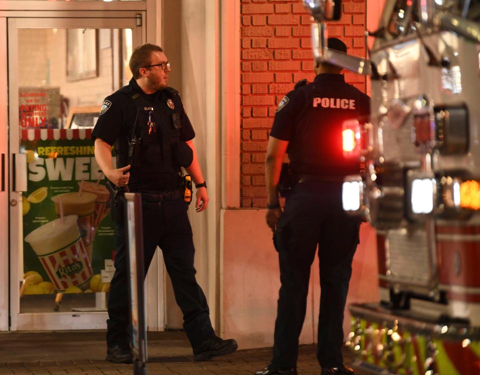 UAPD officer Will Clark, left, waits for fire department EMTs to gather equipment outside a business on The Strip where a patron had fallen ill. The University of Alabama Police Department is putting more officers on The Strip this fall to help with law enforcement in the popular restaurant, bar, and entertainment area. Friday, Aug. 18, 2023.