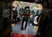 FILE PHOTO: Passengers wearing masks inside a train in Tokyo, Japan