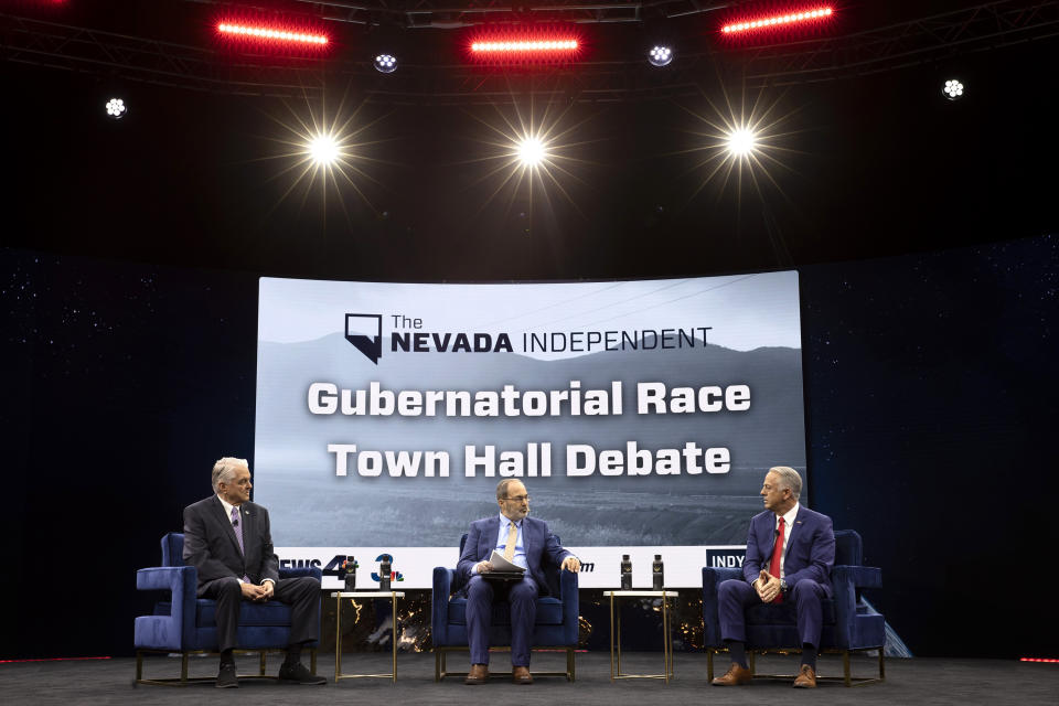 The Nevada Independent CEO Jon Ralston, center, moderates a debate between Nevada Gov. Steve Sisolak, left, and Nevada Republican gubernatorial nominee Joe Lombardo in a town hall during IndyFest at Worre Studios, Sunday, Oct. 2, 2022, in Las Vegas. (AP Photo/Ellen Schmidt)