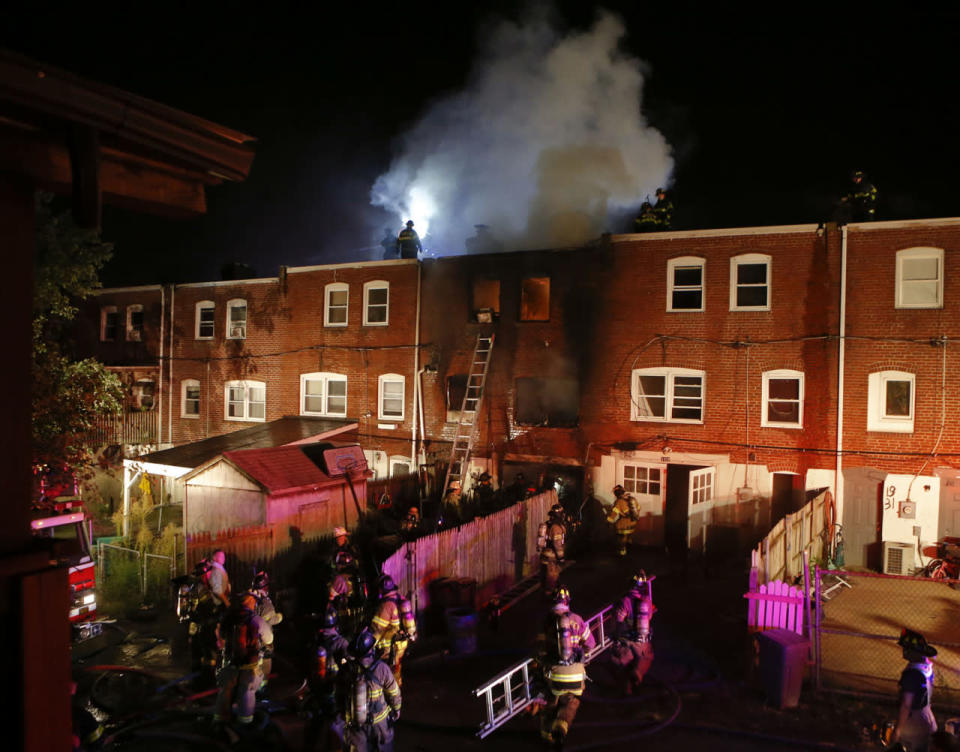 <p>Firefighters work at a rowhome fire on Lakeview Road after a fire was reported shortly after 3:00 a.m. Saturday morning. Two firefighters were killed and four others injured after a floor collapse. (Photo: AP)</p>