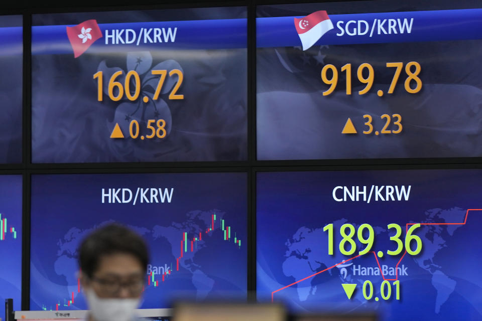 A currency trader stands near the screens showing the foreign exchange rates at a foreign exchange dealing room in Seoul, South Korea, Wednesday, May 25, 2022. Asian stock markets were mixed Wednesday after Wall Street sank on weak U.S. housing sales and a profit warning by a prominent social media brand. (AP Photo/Lee Jin-man)