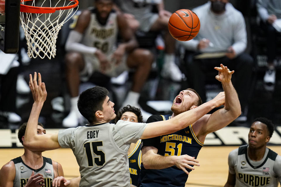 Purdue center Zach Edey (15) fouls Michigan forward Austin Davis (51) during the first half of an NCAA college basketball game in West Lafayette, Ind., Friday, Jan. 22, 2021. (AP Photo/Michael Conroy)