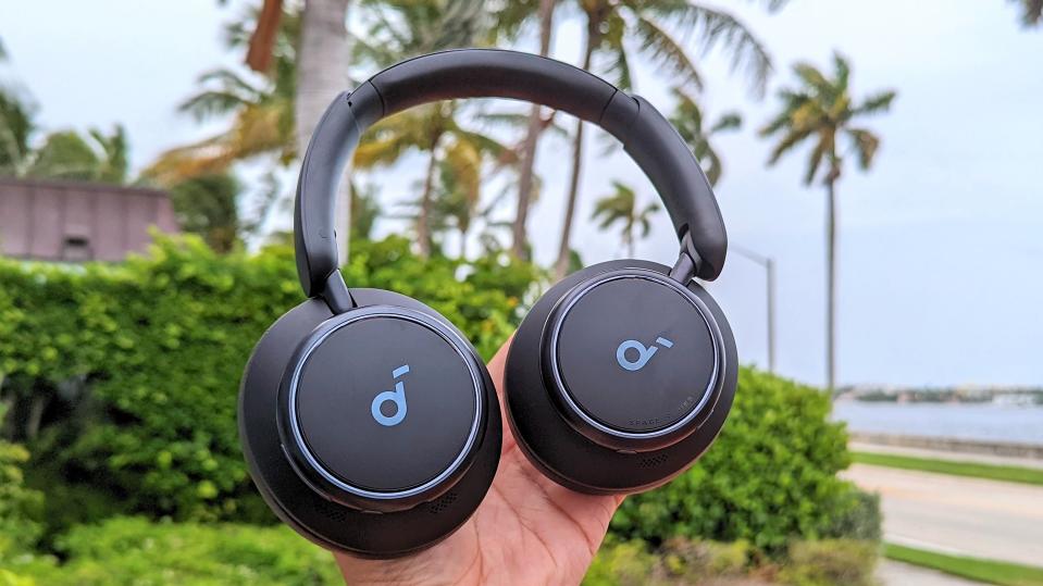 Anker Soundcore Space Q45 headphones placed in reviewer's hand with outdoors Florida scene in background