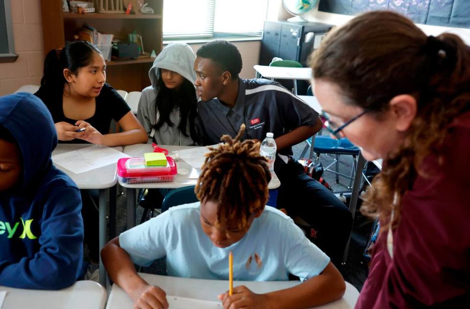 Jahzar Fields works with Perla Ramirez Urieta, left, and Alandra Gonzalez Alvarez while student teaching in Kerry Miquel’s 6th grade social studies class at Dillard Drive Magnet Middle School in Raleigh, N.C., Wednesday, Sept. 6, 2023.