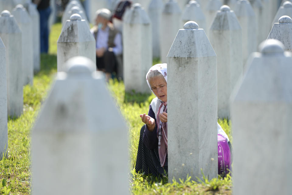 A woman prays in Potocari, near Srebrenica, Bosnia, Saturday, July 11, 2020. Nine newly found and identified men and boys were laid to rest as Bosnians commemorate 25 years since more than 8,000 Bosnian Muslims perished in 10 days of slaughter, after Srebrenica was overrun by Bosnian Serb forces during the closing months of the country's 1992-95 fratricidal war, in Europe's worst post-WWII massacre. (AP Photo/Kemal Softic)