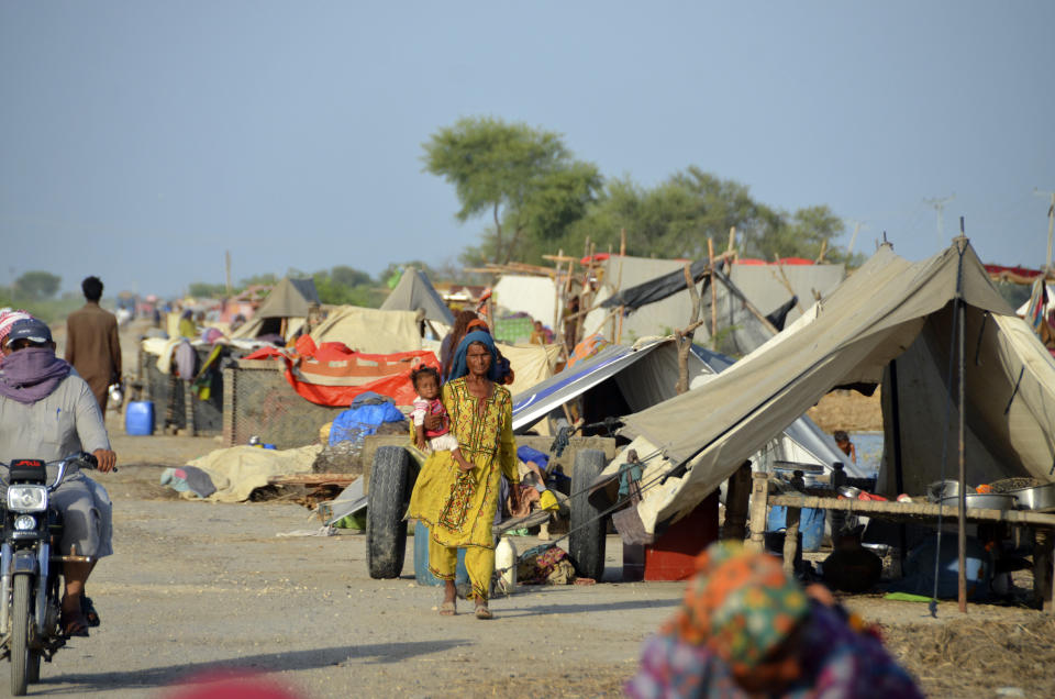 Families take a refuge on the road after leaving their flood-hit homes, in Jaffarabad, a district of Baluchistan province, Pakistan, Monday, Sept. 19, 2022. Pakistan said Monday there have been no fatalities for the past three days from the deadly floods that engulfed the country since mid-June, a hopeful sign that the nation is turning a corner on the disaster. (AP Photo/Zahid Hussain)