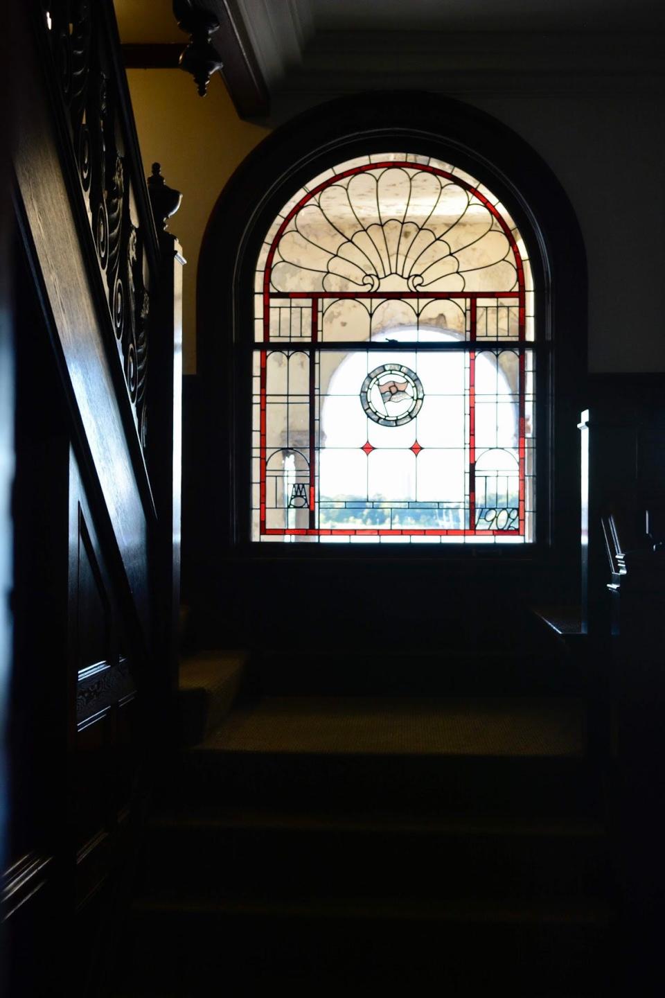The stained glass window, pictured in July 2021, is located at the landing of the boathouse’s main staircase, features the club’s flag, year of construction and the interlocking initials of its architect, Alpheus Williams Chittenden. The window was restored by Sevonty Restoration in two phases.
