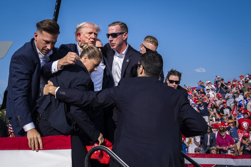 Secret Service agents remove Donald Trump from the stage 