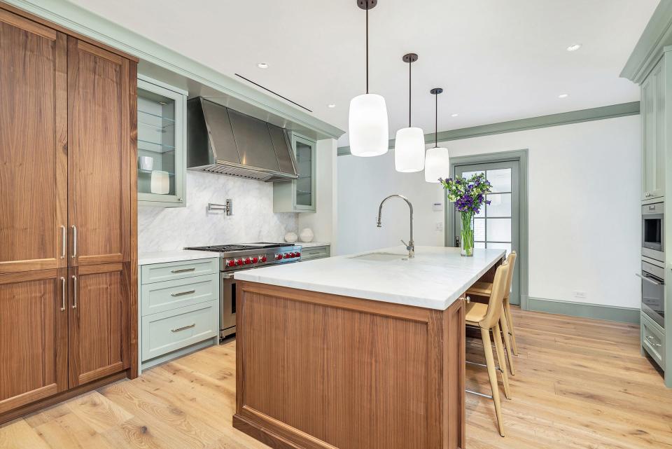 The work island in the revamped kitchen is made of walnut. The pendant lights were reclaimed from a church in the Netherlands.