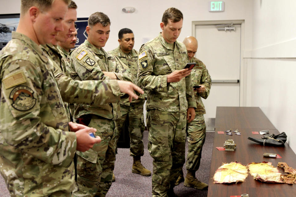 Alaska-based military members who participated in a search for human remains and personal items from the 1952 crash of a C-124 Globemaster view some of the items that were found, Tuesday, Sept. 29, 2021, at Joint Base Elmendorf-Richardson, Alaska. The plane slammed into a mountain, killing 52 on board, the plane and its crew have since become part of the glacier. The military has conducted annual summer recovery efforts, finding human remains and personal items on the glacier. (AP Photo/Mark Thiessen)