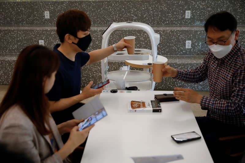 A robot that takes orders, makes coffee and brings the drinks straight to customers delivers an order in a cafe in Daejeon