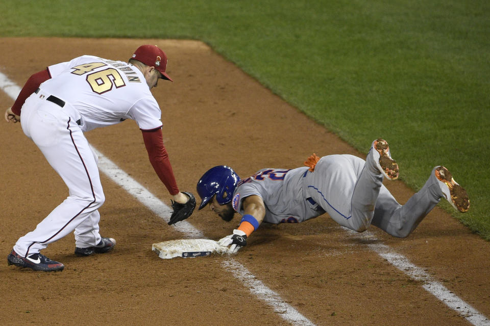 New York Mets' Robinson Chirinos, right, slides safely into first against Washington Nationals starting pitcher Patrick Corbin (46) during the sixth inning of a baseball game, Thursday, Sept. 24, 2020, in Washington. The Mets won 3-2. (AP Photo/Nick Wass)