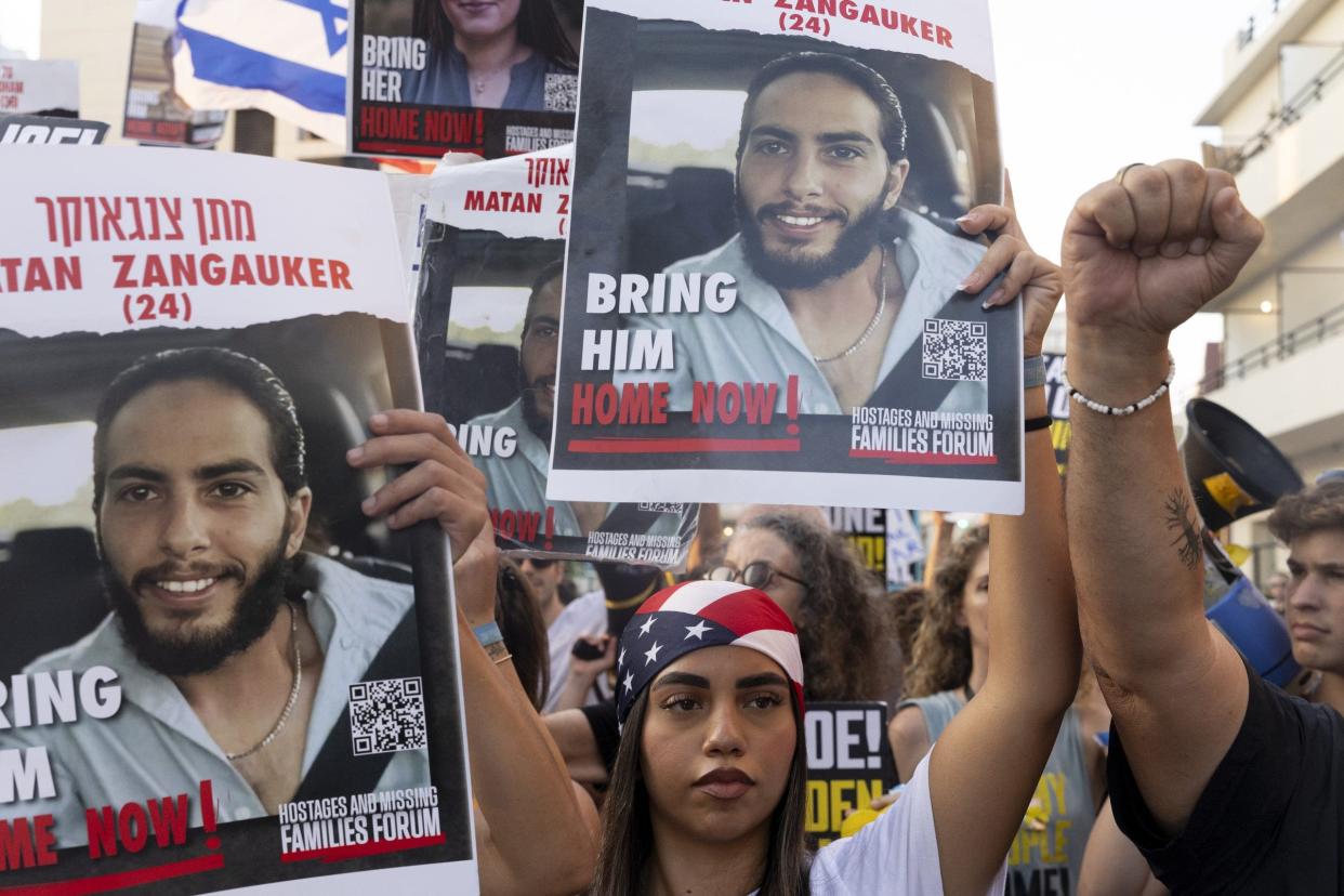 Families of hostages who were kidnaped by Hamas in the Oct. 7 deadly attack and supporters hold signs and U.S. flags during a demonstration outside a press event by U.S. Secretary of State Antony Blinken on August 19, 2024, in Tel Aviv, Israel.