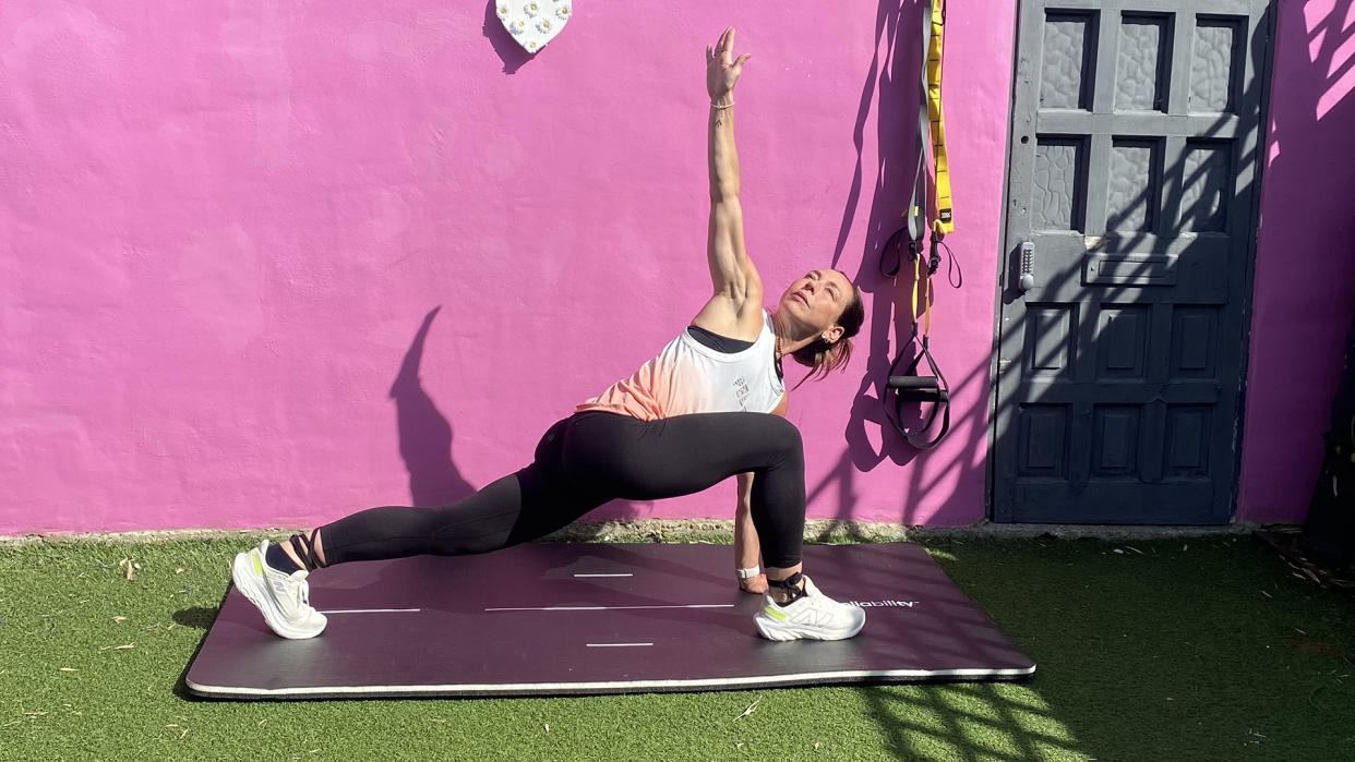  The author performing runners' lunges in front of pink wall outdoors. 