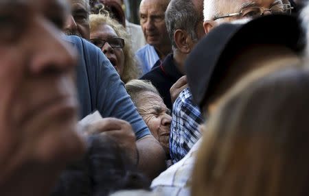 A pensioner (C) is squeezed as she waits outside a National Bank branch to receive part of her pension in Athens, Greece in this July 1, 2015 file photo. REUTERS/Alkis Konstantinidis/Files