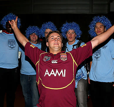 A Maroons fan bravely takes on the Blues in the supporting stakes.