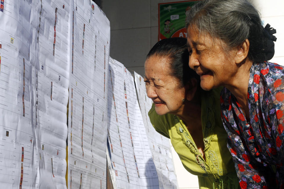 Elderly women check the name lists of parliamentary candidates at a polling station in Bali, Indonesia, Wednesday, April 9, 2014. Polls opened for around 187 million Indonesians eligible to vote in single-day legislative elections, a huge feat in the still-young democracy that's expected to help clear the path for the country's next president. (AP Photo/Firdia Lisnawati)
