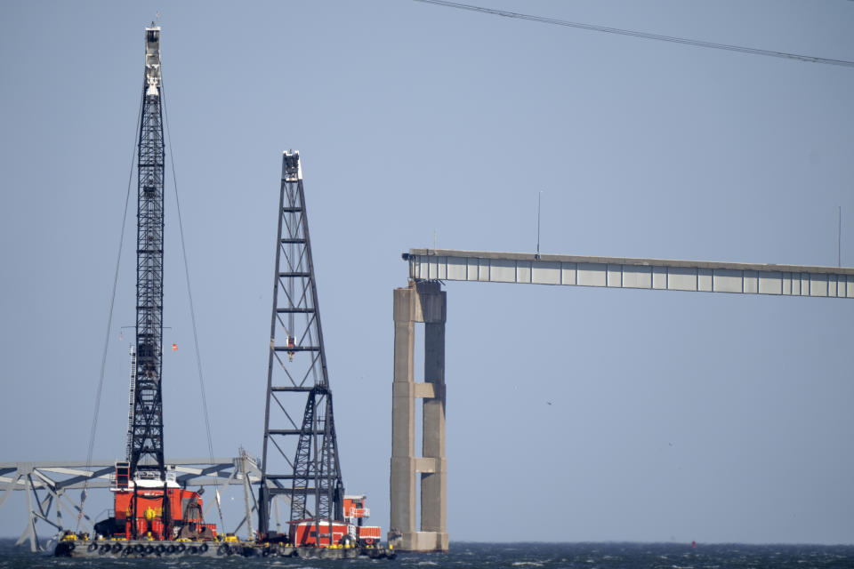 Barges with cranes float near a damaged section of the Francis Scott Key Bridge, Friday, March 29, 2024, in Baltimore, Md. (AP Photo/Mark Schiefelbein)