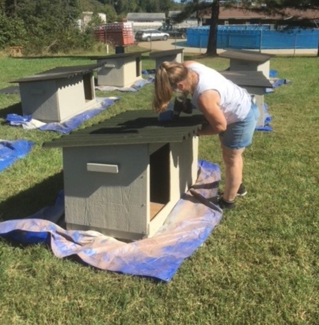 A volunteer works on a doghouse during the annual Dog House Derby.