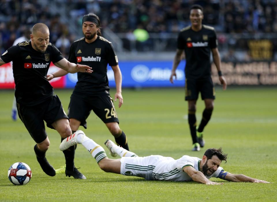 Portland Timbers midfielder Diego Valeri falls after being tackled by LAFC defender Jordan Harvey.