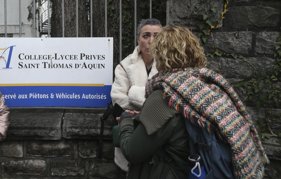 People gather outside a private Catholic school after a teacher has been stabbed to death by a high school student, Wednesday, Feb. 22, 2023 in Saint-Jean-de-Luz, southwestern France. The student has been arrested by police, the prosecutor of Bayonne said. (AP Photo/Bob Edme)