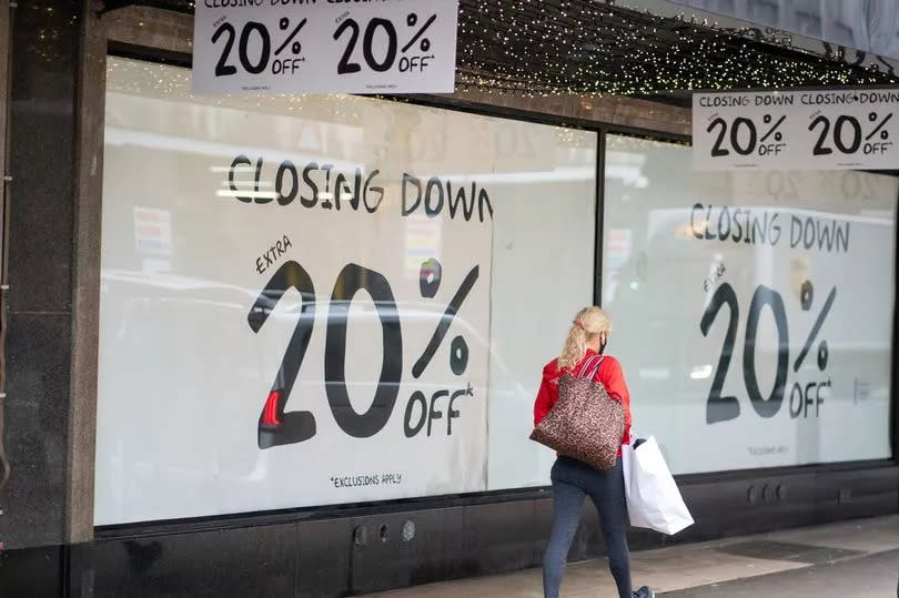 A shopper passes closing down sale signs in a shop. Latest research shows business insolvency rates are slowing.