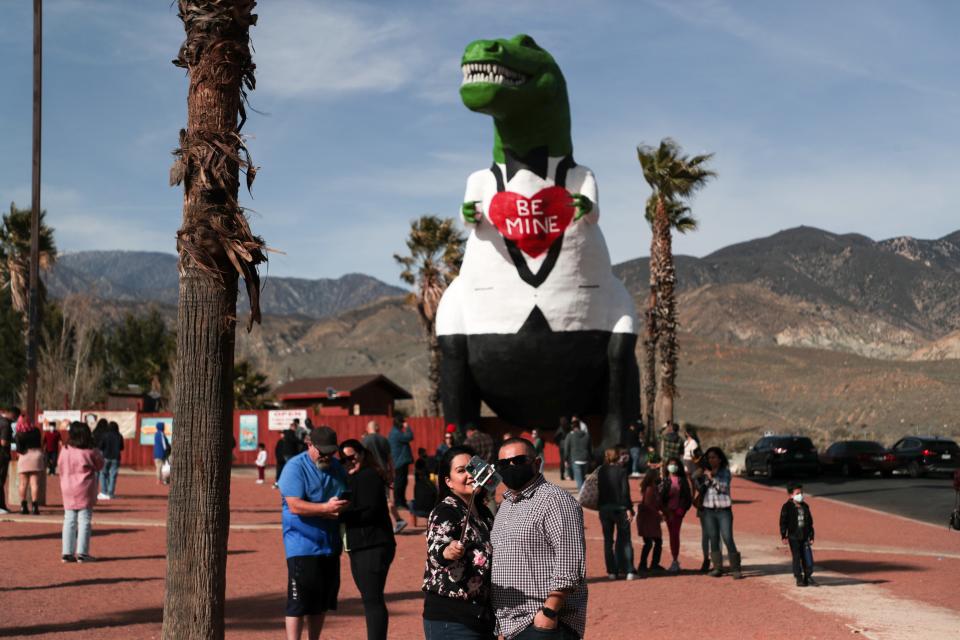 Crowds celebrate Valentine's Day on Sunday, February 14, 2021, at the Cabazon Dinosaurs roadside attraction, which was painted for the holiday.