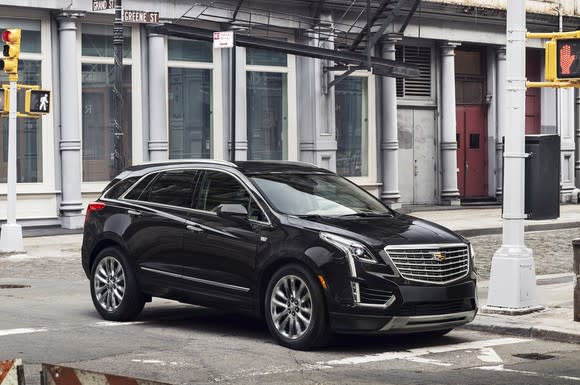 A black Cadillac XT5, a midsize crossover SUV, on a city street.