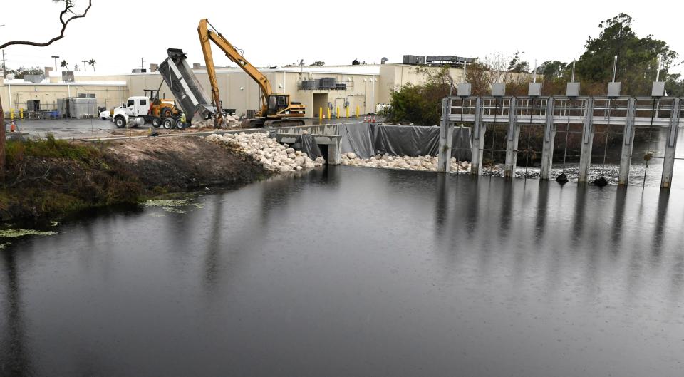 Workers fill in a portion of the bank of the Cocoplum Waterway in North Port at Water Control Structure 106.That portion of the bank was eroded by floodwater from Hurricane Ian.