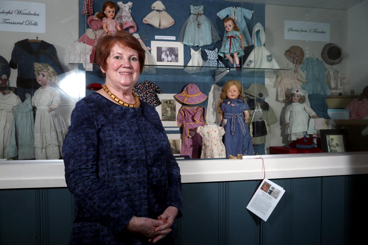 Curator Sue Whitaker stands with the new "Wonderful Wardrobes for Treasured Dolls: Stories from Three Families" exhibit Feb. 16 at the Worthington Historical Society's Doll Museum.