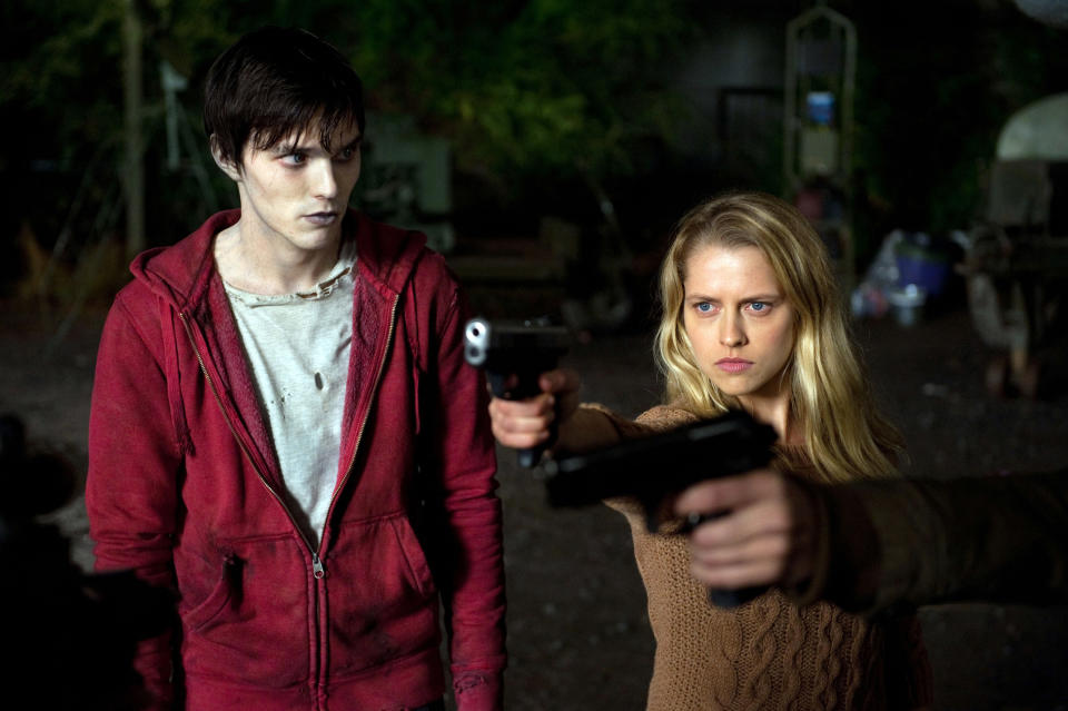 Nicholas Hoult looking at Teresa Palmer, who is pointing her gun offscreen