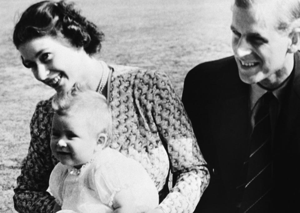 FILE - In this July 18, 1949 file photo, Britain's Prince Charles, foreground left, the eight-month-old son of Princess Elizabeth of England, left, and his father Philip, pose for a photo, on the Windlesham Moor, their summer residence, in Ascot, England. Prince Charles turns 70 Wednesday Nov. 14, 2018, still serving in the heir to the throne role he has filled since he was a young child. (AP Photo, File)