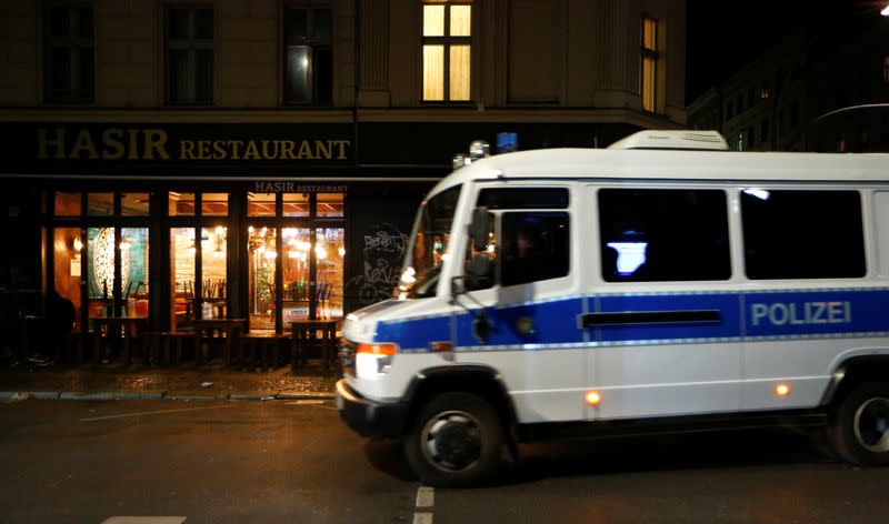 A police car drives in front of a closed restaurant is pictured during the late-night curfew due to restrictions against the spread of the coronavirus disease (COVID-19) in Berlin