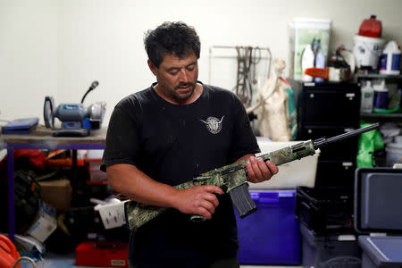 Noel Womersley displays his AR-15 semi-automatic rifle which he keeps in the garage of his house outside Christchurch, New Zealand March 27, 2019. REUTERS/Jorge Silva